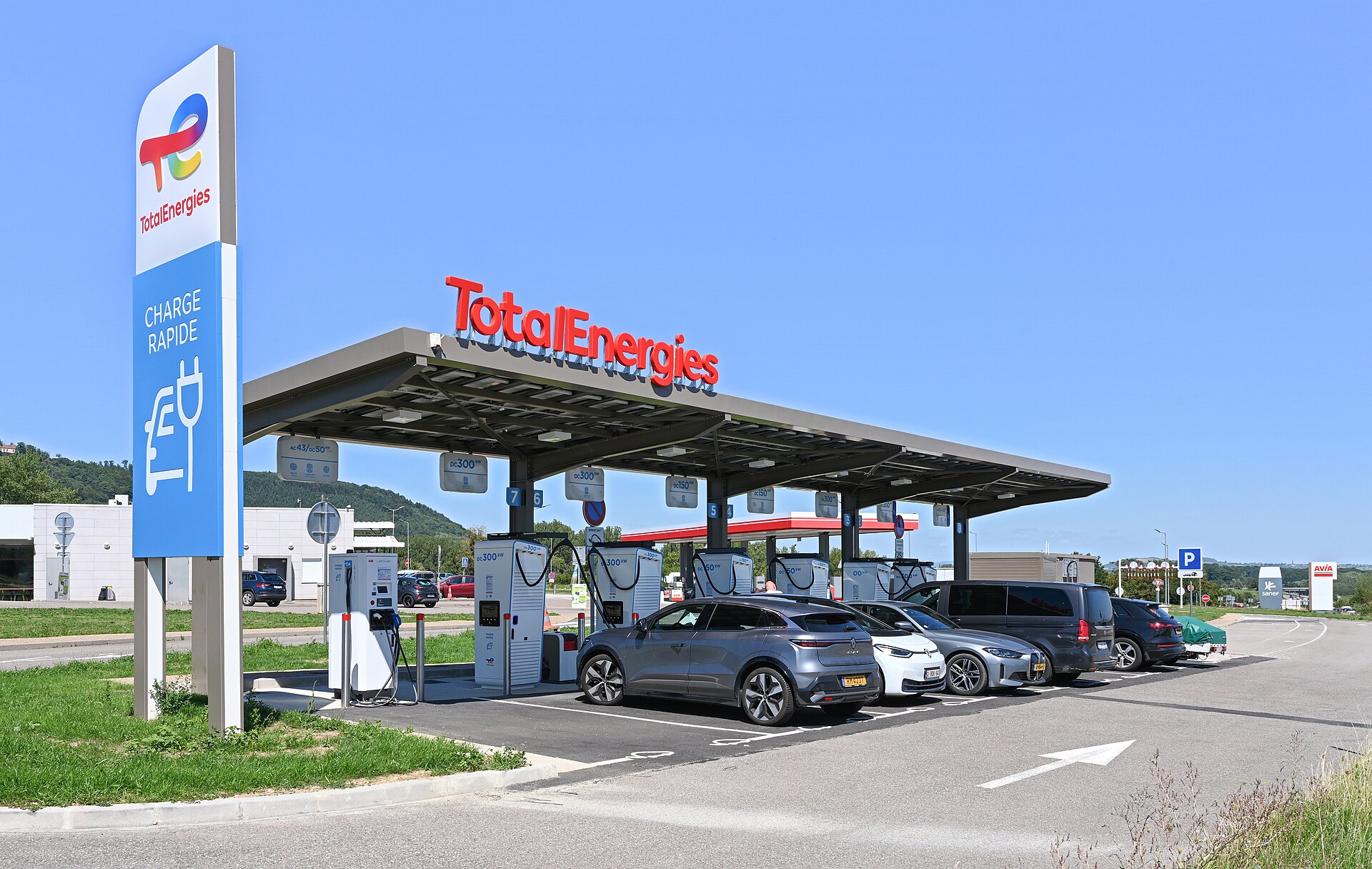 Rapid charging bays under a canopy at a French motorway service area, with several cars plugged in.