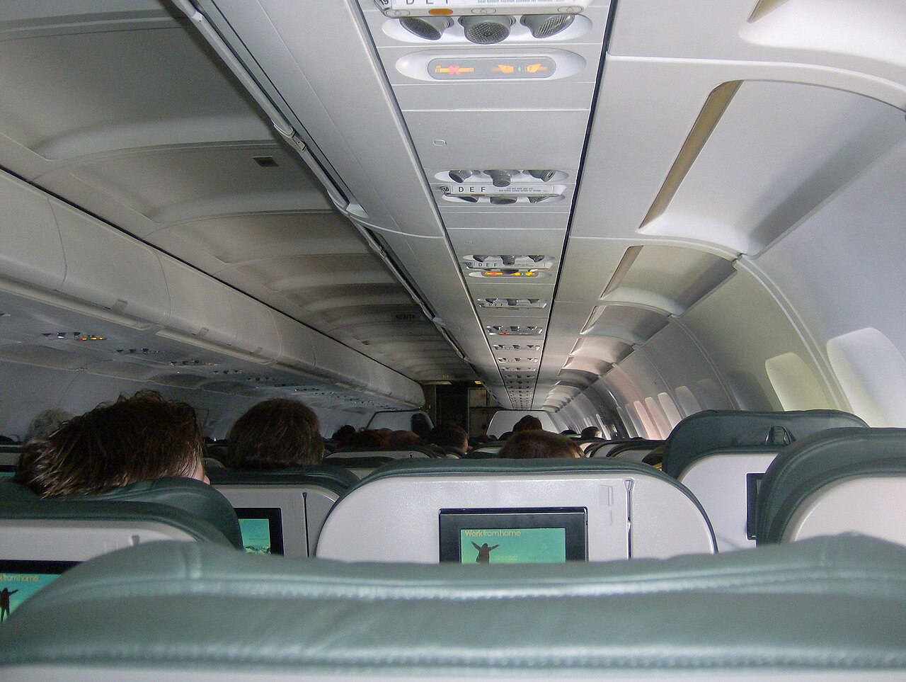 Interior of a narrow-body airliner with overhead lockers and three-abreast seating