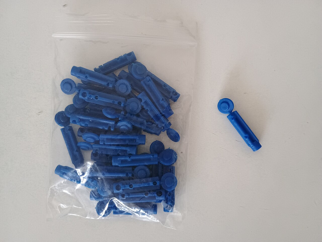 Blood glucose meter with lancing device and test strips laid out together