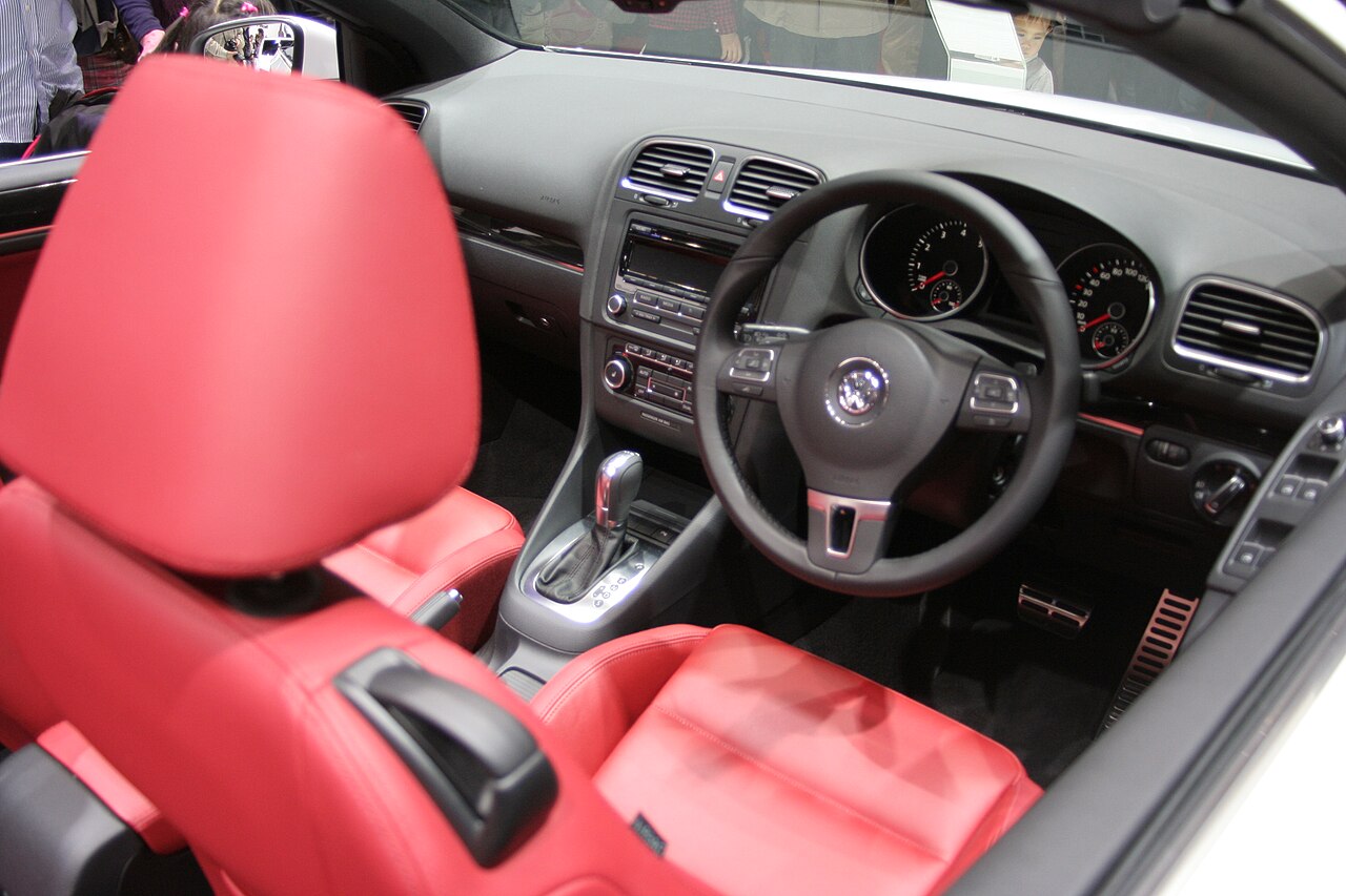 Interior of a convertible showing front seats, dashboard and gear lever