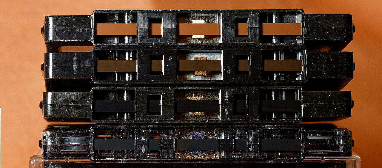 Four cassette tapes laid in a row showing different tape formulations by colour