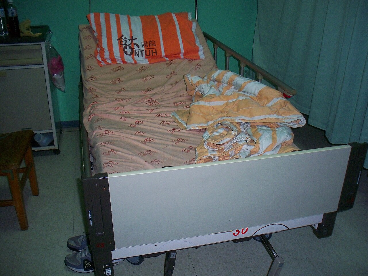 Overhead view of a hospital bed and locker in a shared ward room