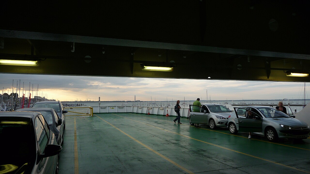 Cars parked in rows on the open upper vehicle deck of a ferry