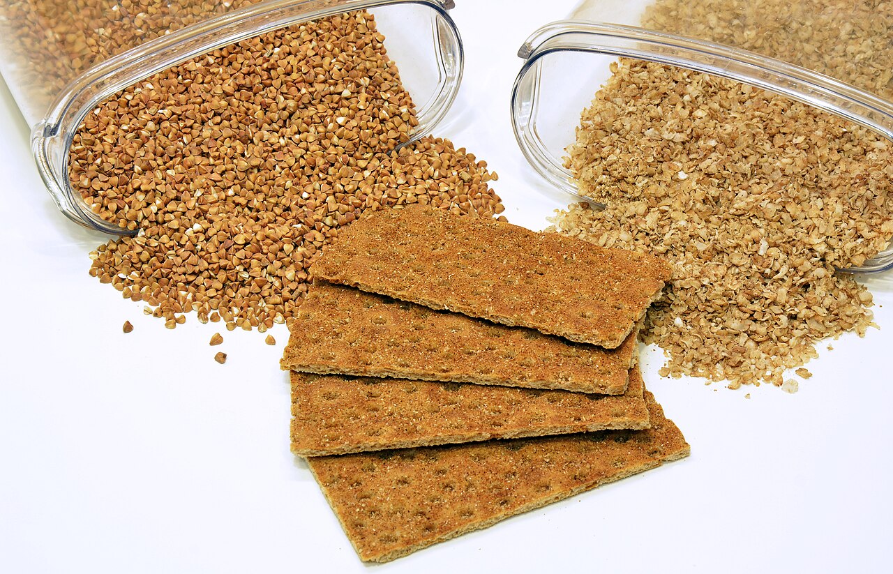 Buckwheat groats beside buckwheat flakes and crispbread made from buckwheat flour