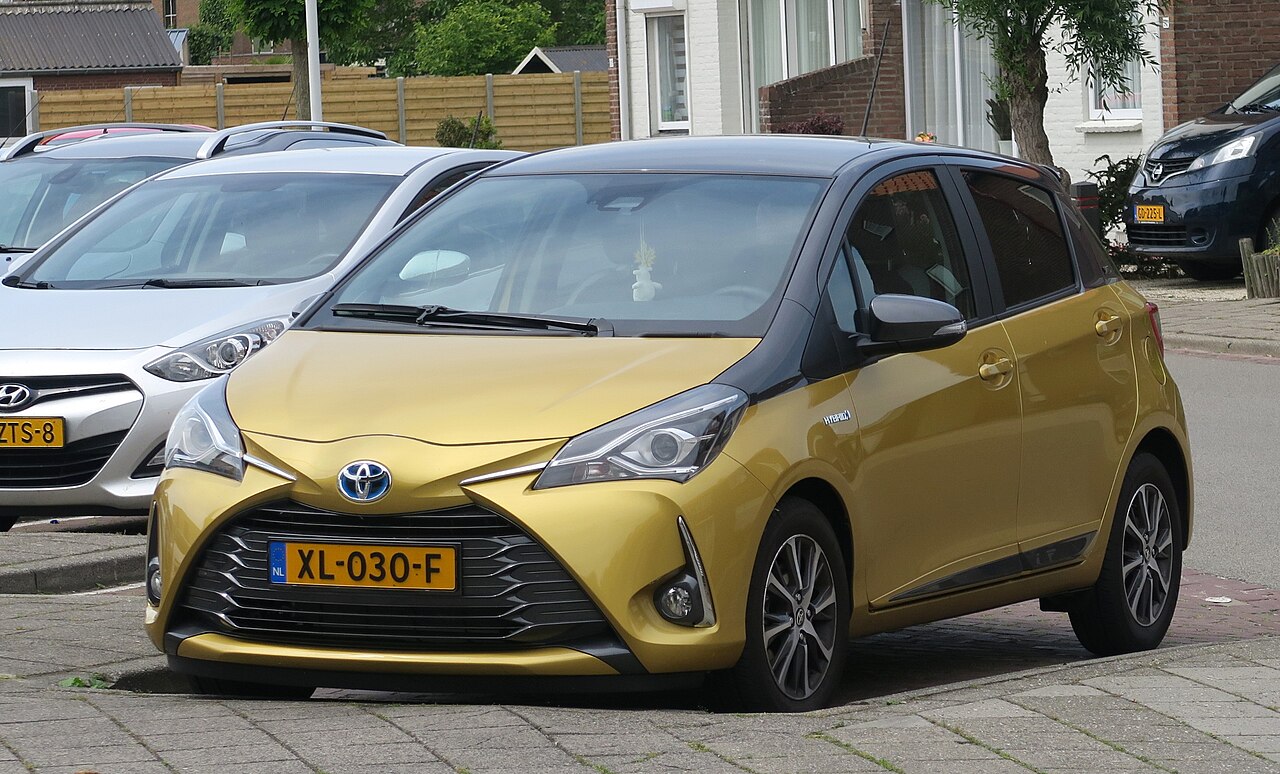 Small hybrid hatchback parked on a quiet street in a Dutch town