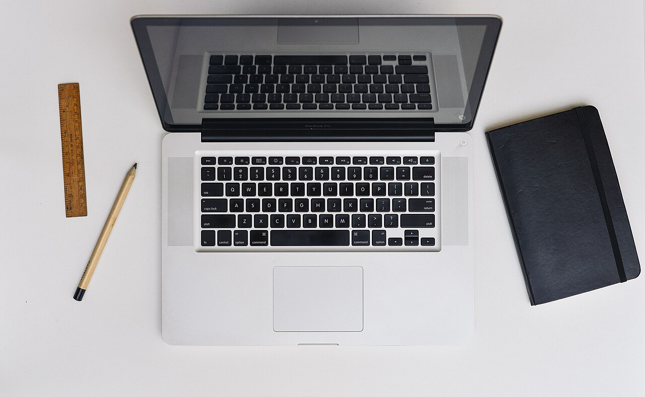 Open laptop on a wooden desk photographed from above