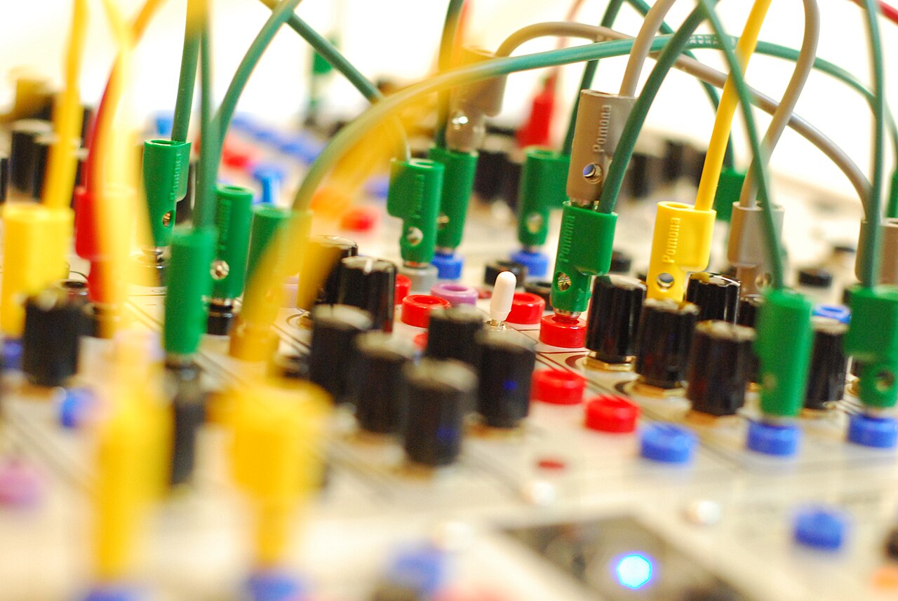 Serge modular synthesizer panel criss-crossed with patch cables
