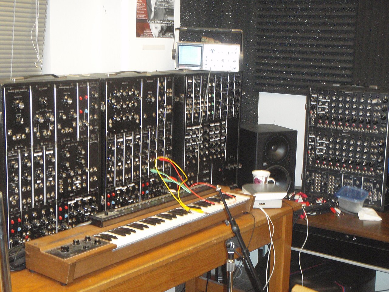 Large cabinet-mounted modular synthesizer with an analogue sequencer beside it