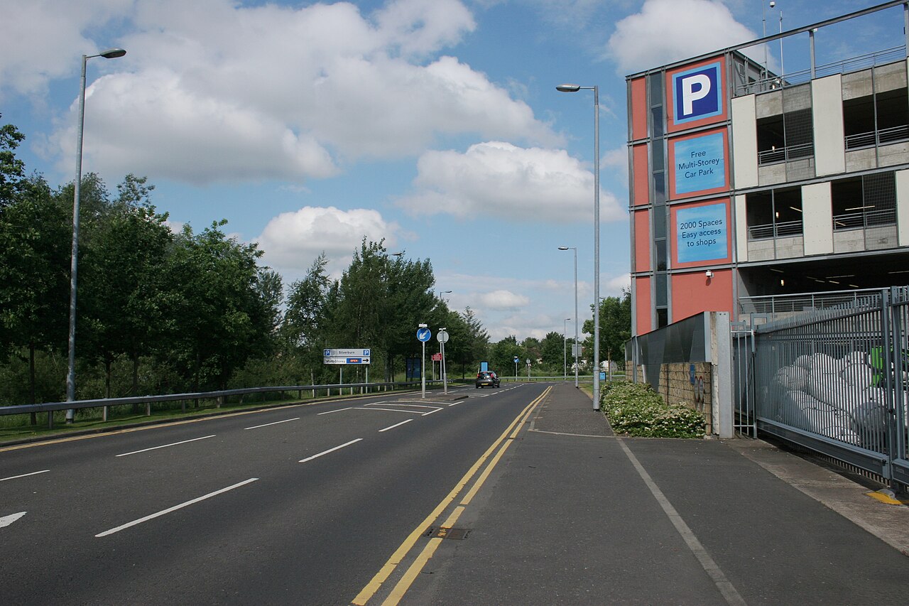 Shopping centre multi-storey car park with cars on the open top deck
