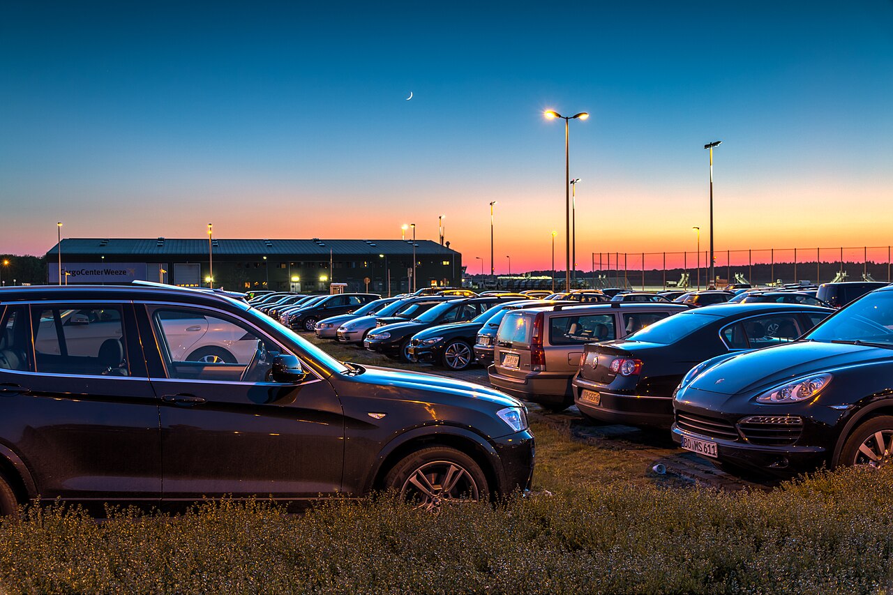 Rows of parked cars in a large open airport car park