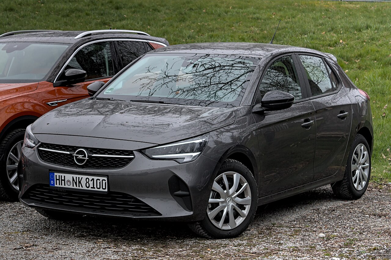 Small hatchback parked on a street, photographed from the front and side