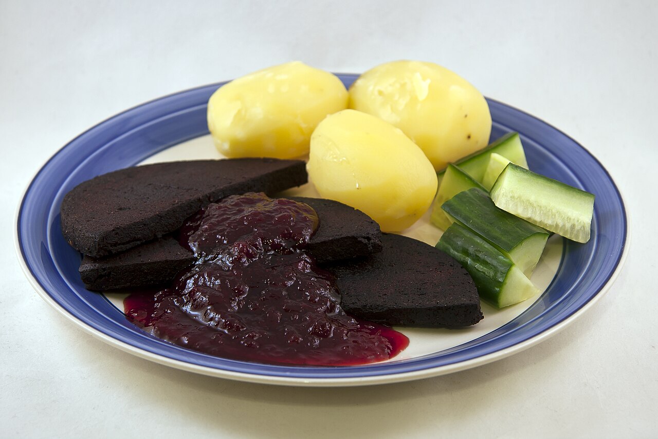 Swedish black pudding served with boiled potatoes, lingonberry jam and cucumber
