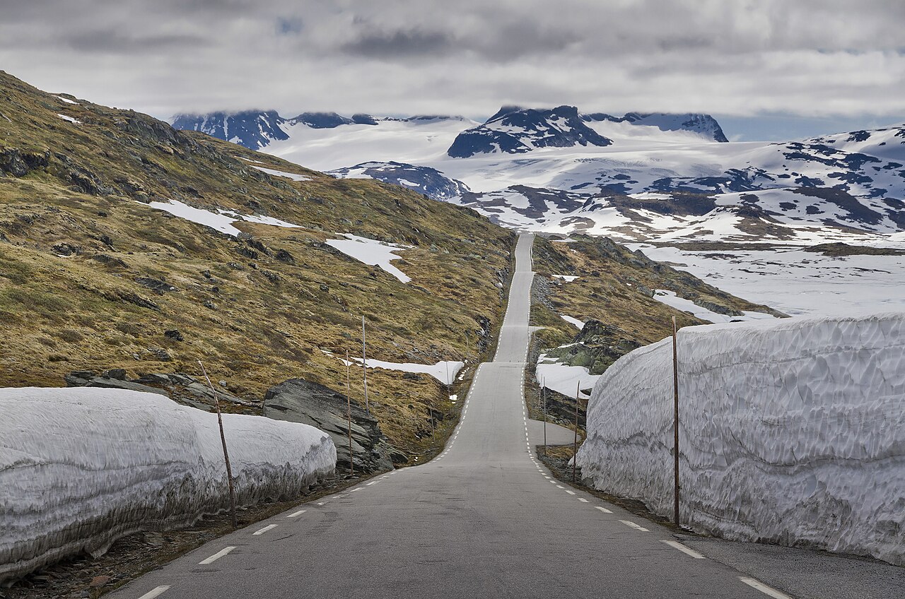 Norwegian mountain road cut between high walls of snow in early summer