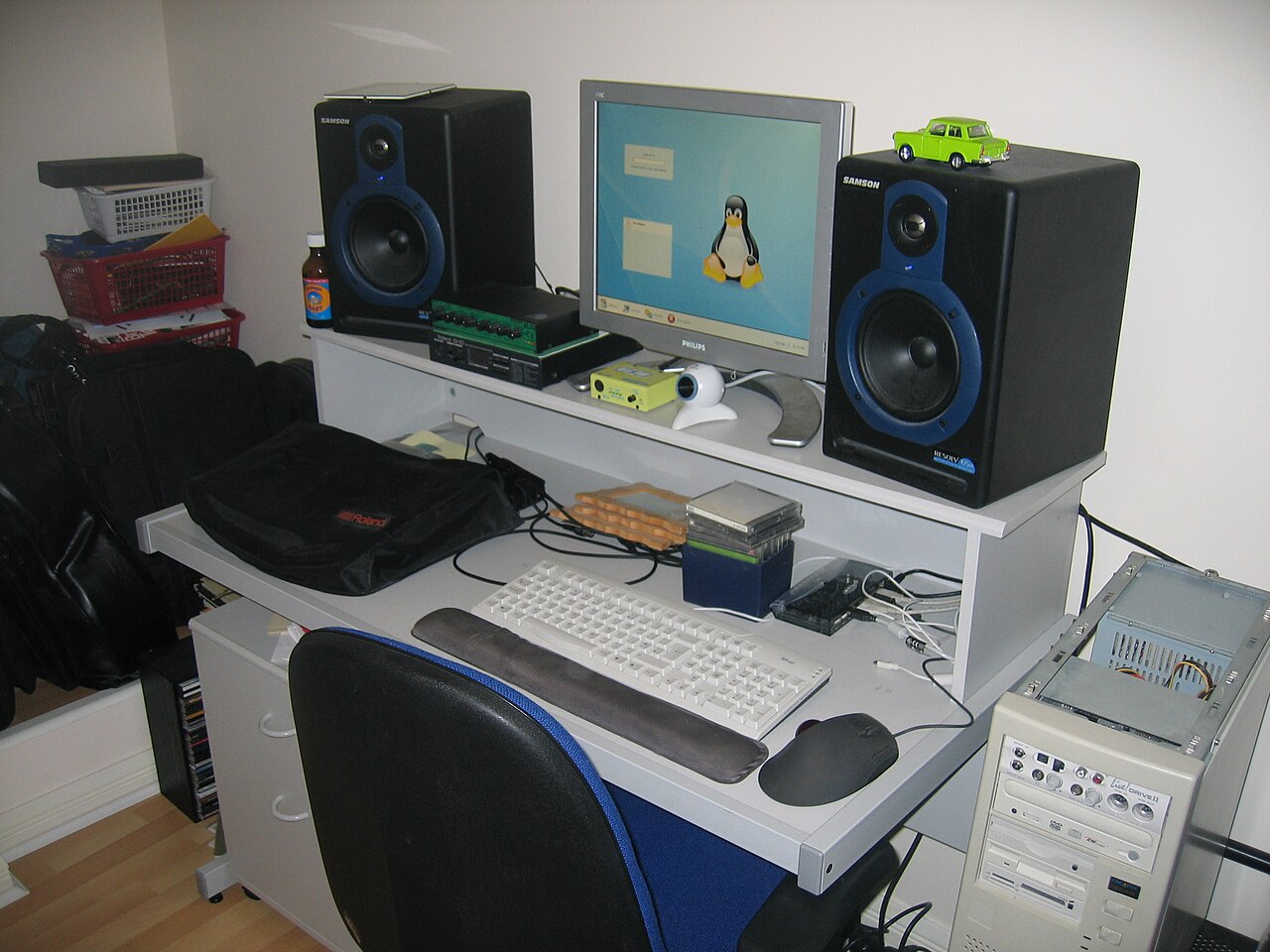 Home studio desk with computer, keyboard controller and outboard gear stacked around it