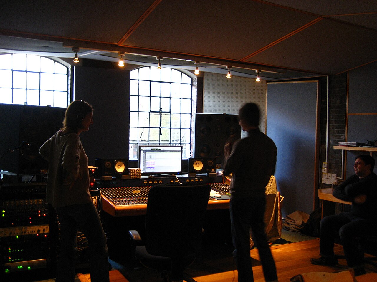 Analogue mixing desk in a studio control room with outboard racks behind