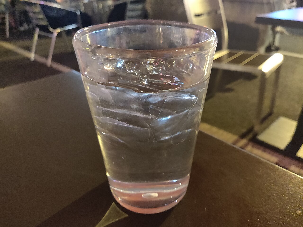 Glass of iced water standing on an outdoor dining table