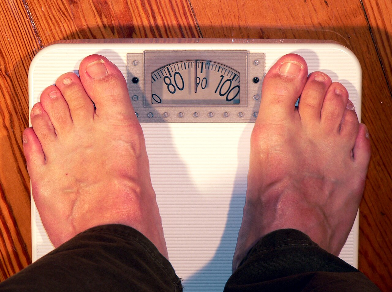 Bare feet standing on a bathroom weighing scale